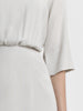 Sleeve close up view on a model wearing a sand color blouson dress from the RÉZO women's collection