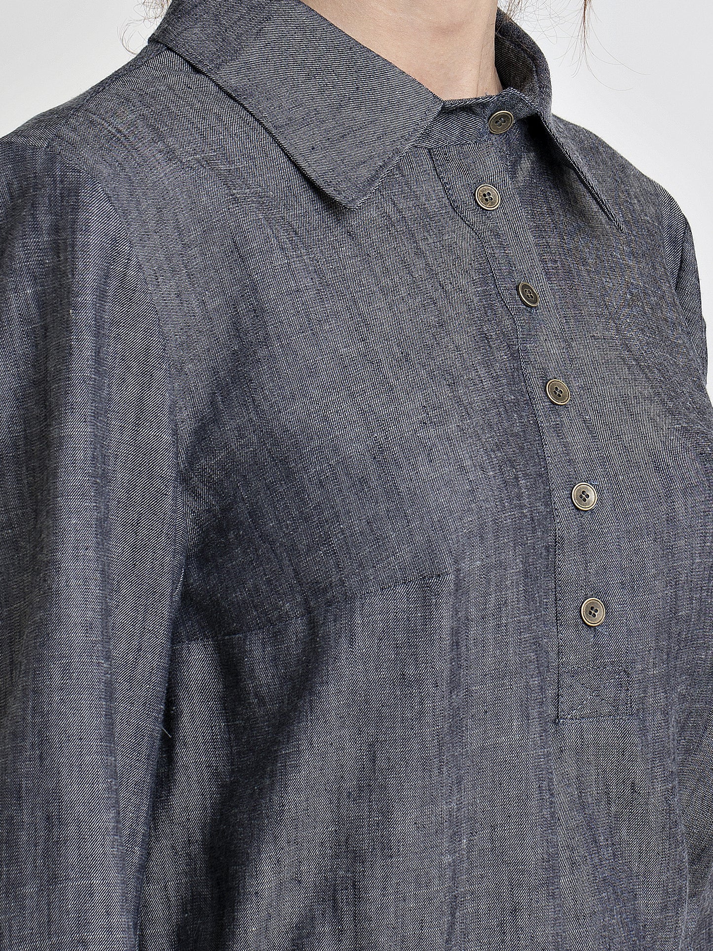 Placket close up view of a female model wearing a long sleeve denim dress. From the RÉZO women's collection.