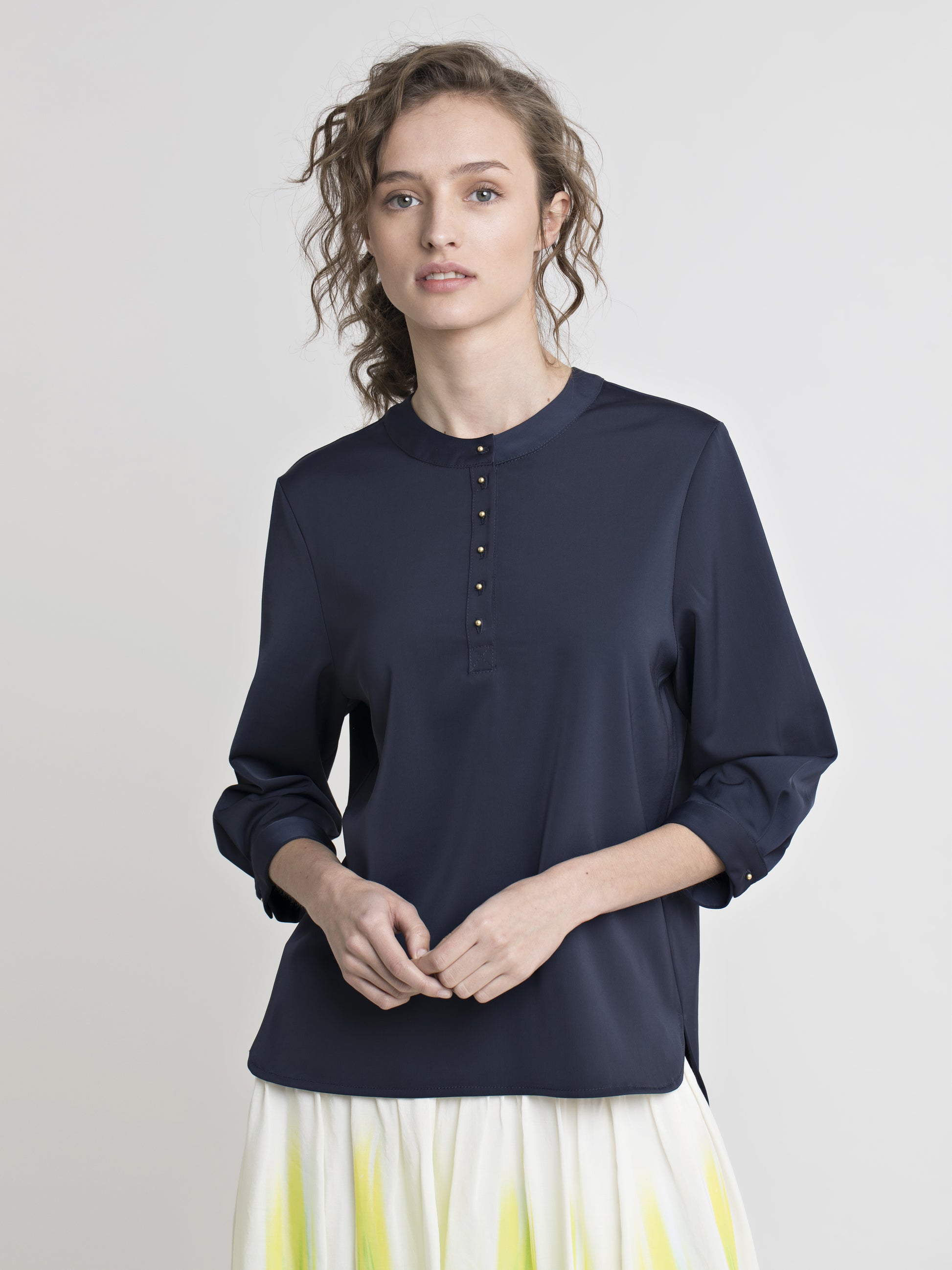 Navy blue satin blouse featuring high crew neck, elbow sleeve, and gold color buttons